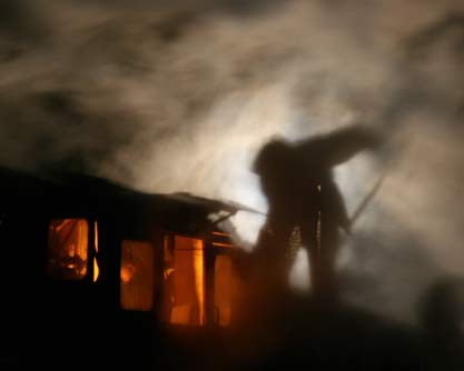 Fireman trimming coal at night in steam locomotive tender in China, photo by Scott Lothes
